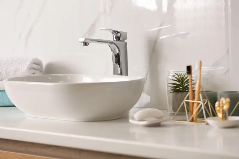 Stylish vessel sink on light countertop in modern bathroom